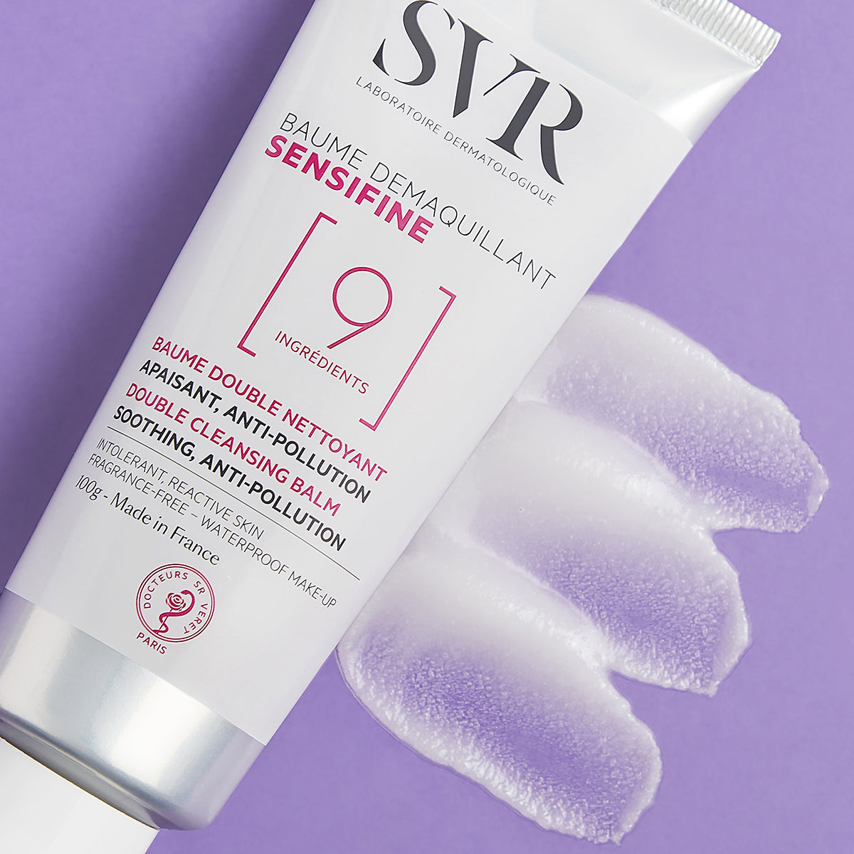 Tube de baume démaquillant SVR Sensifine 100g avec une texture onctueuse étalée sur fond violet.