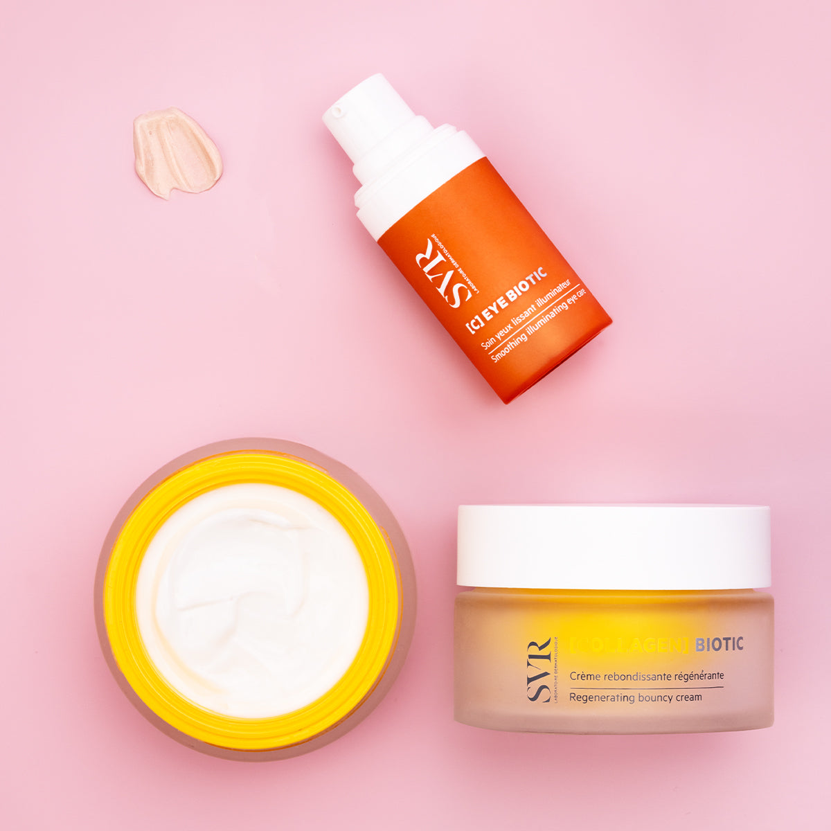 SVR C-Eye Biotic pump bottle and Collagen Biotic cream jar with white lids on a pink background.