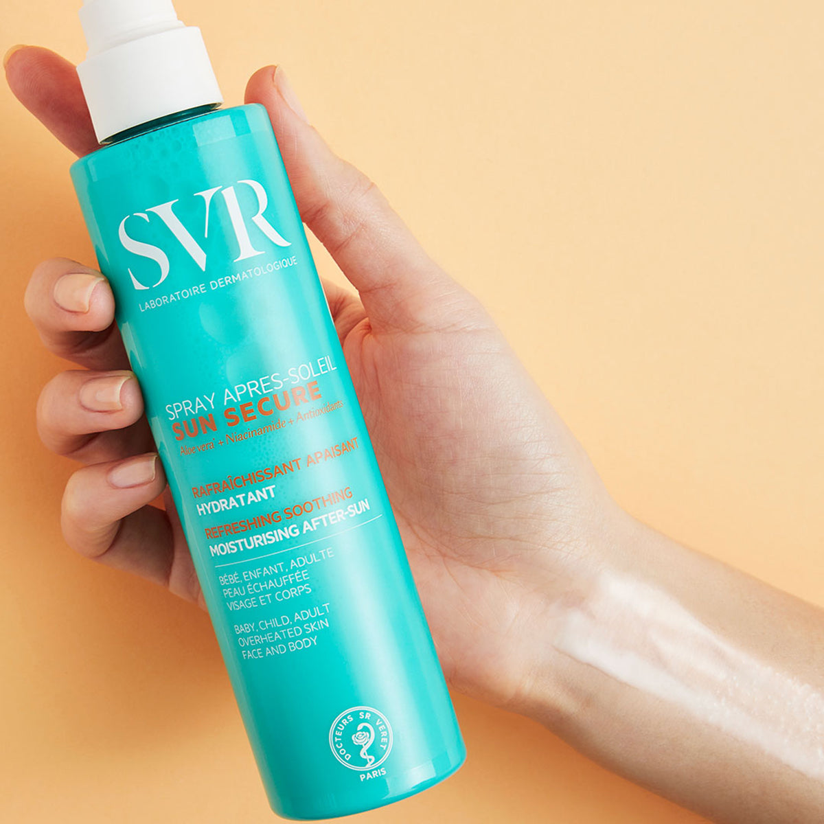 Flacon spray turquoise SVR Sun Secure après-soleil tenu en main avec une texture légère appliquée sur la peau.