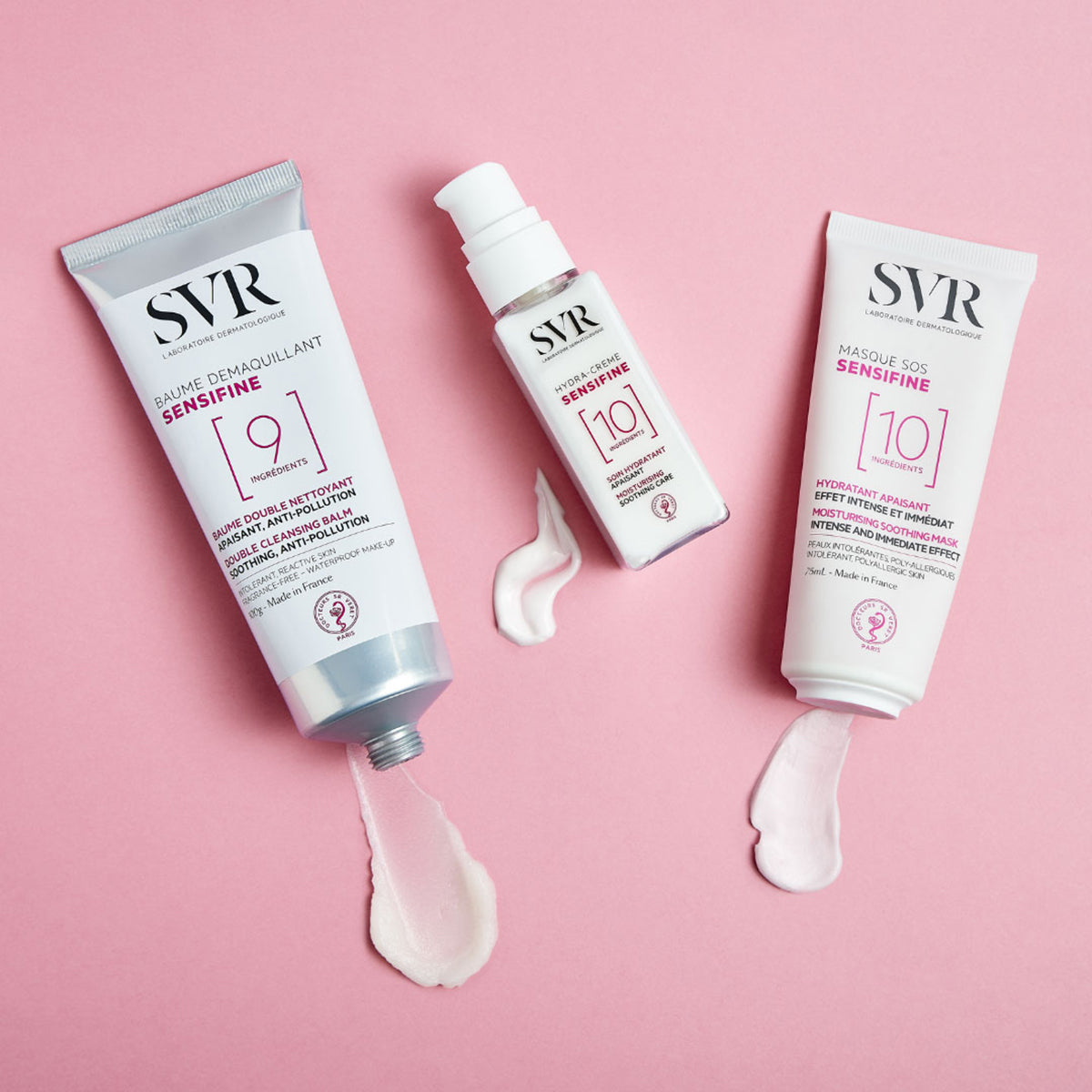 Trois tubes de soins SVR Sensifine avec textures crème sur fond rose pastel.